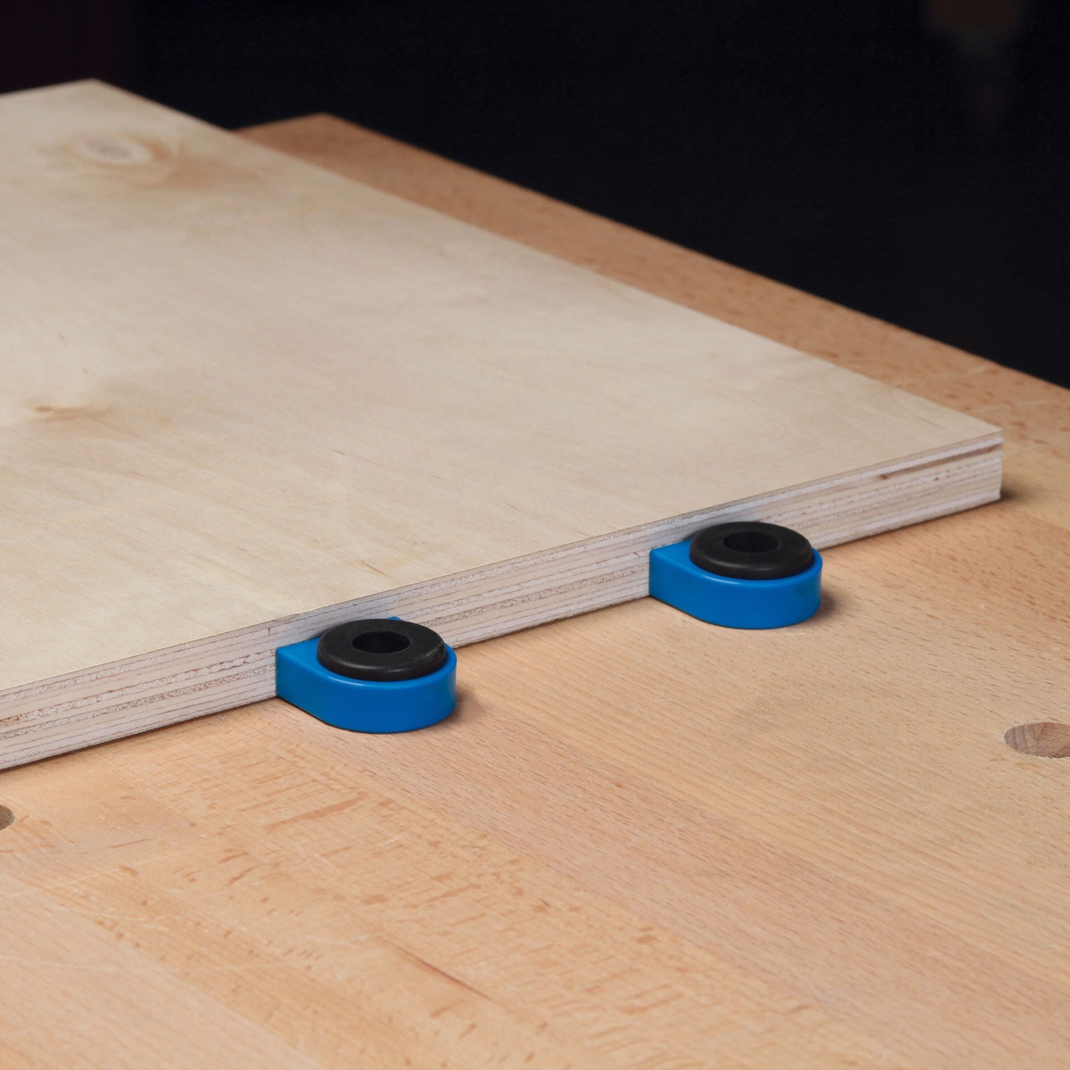 Kreg Bench Dogs and Bench Brakes (4-Pack) supporting a plywood panel on a workbench for positioning and control