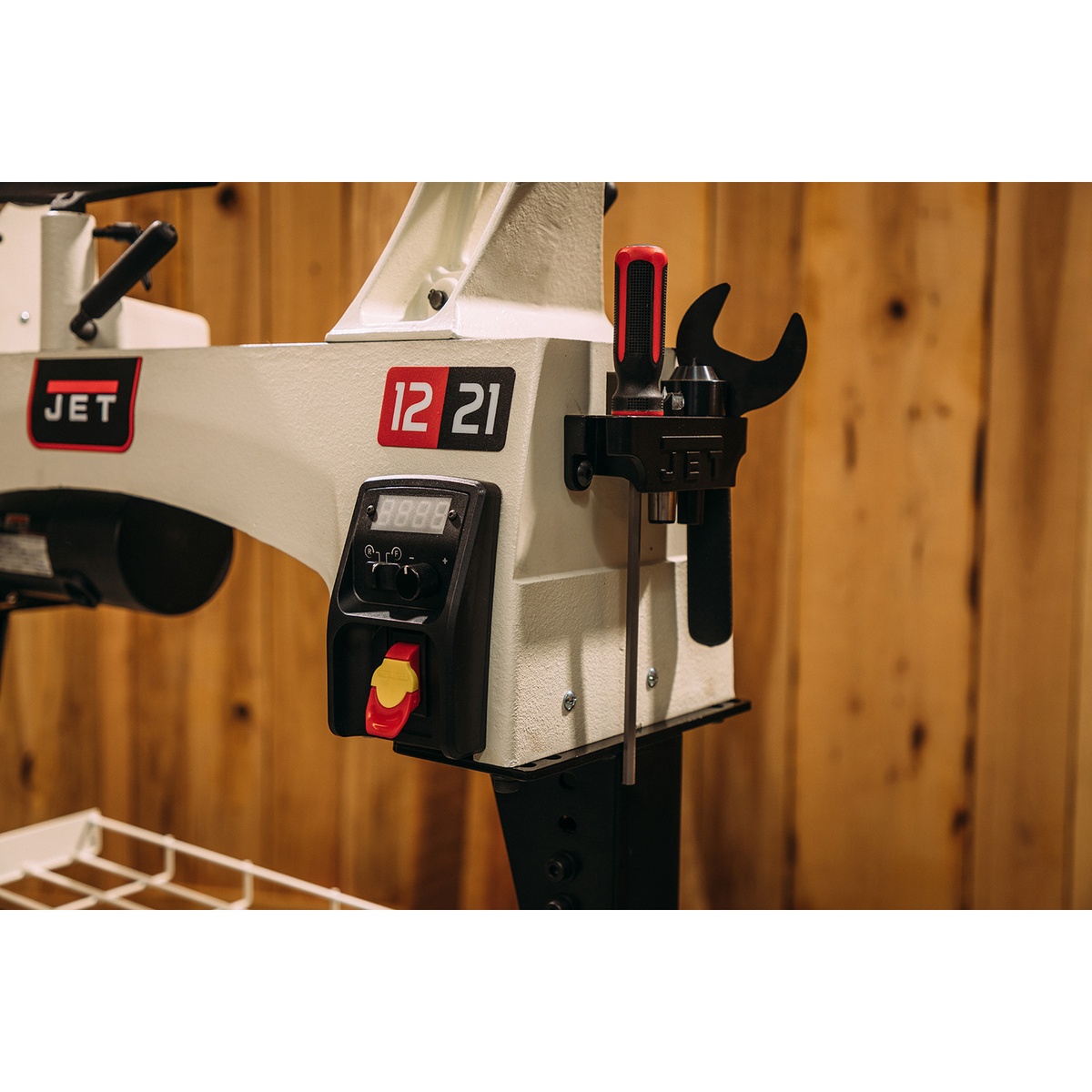 Jet 719200 JWL-1221VS 12 x 21 variable speed wood lathe showing front controls, recessed power switch, and onboard tool holder in a woodworking shop