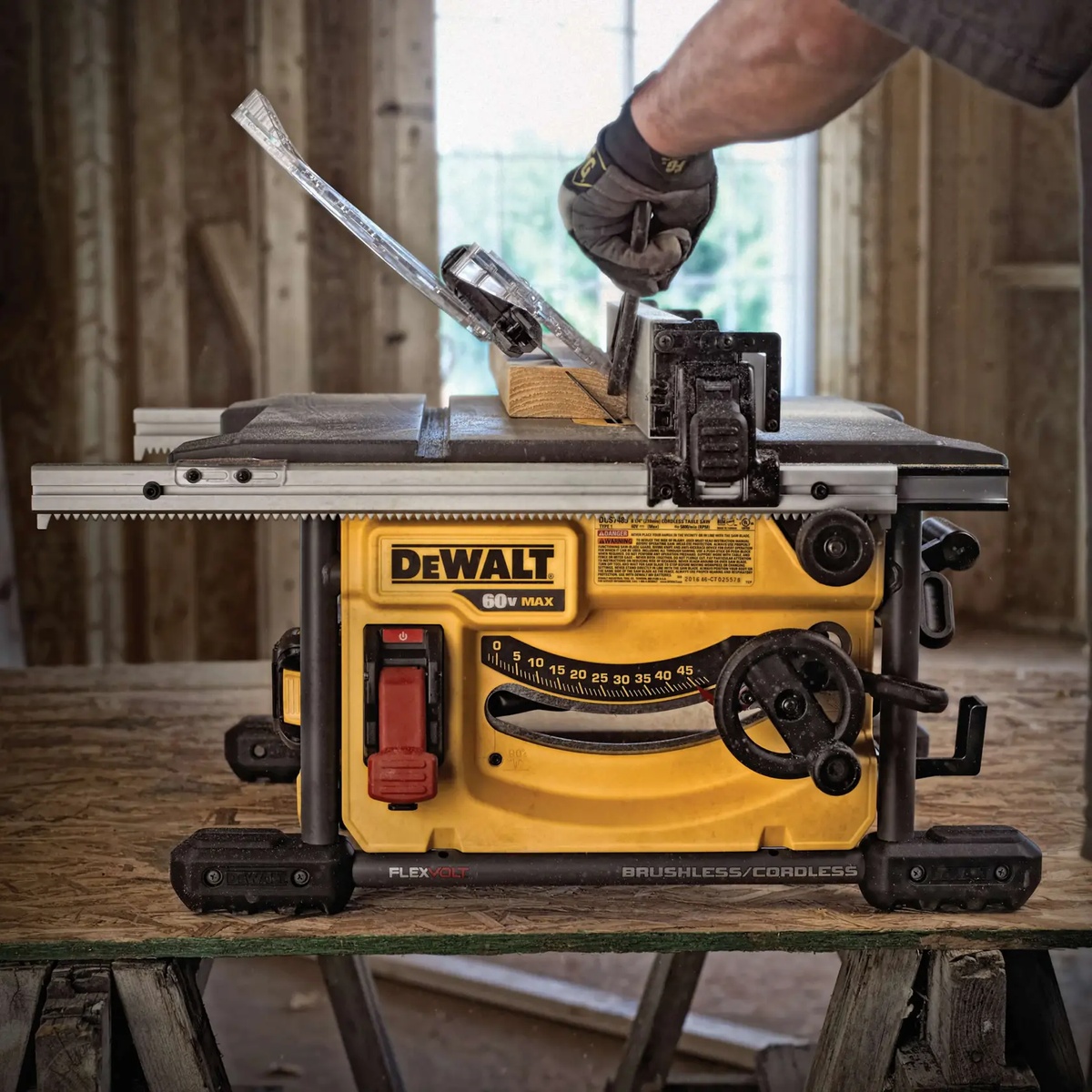 DEWALT DCS7485T1 FLEXVOLT 60V MAX 8-1/4 in. table saw cutting lumber indoors with guard system installed during jobsite ripping work