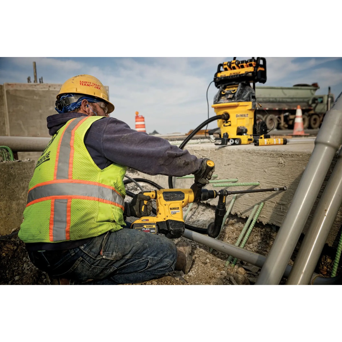 DEWALT 1800W Portable Power Station and Simultaneous Battery Charger powering a corded rotary hammer during concrete drilling on a construction jobsite