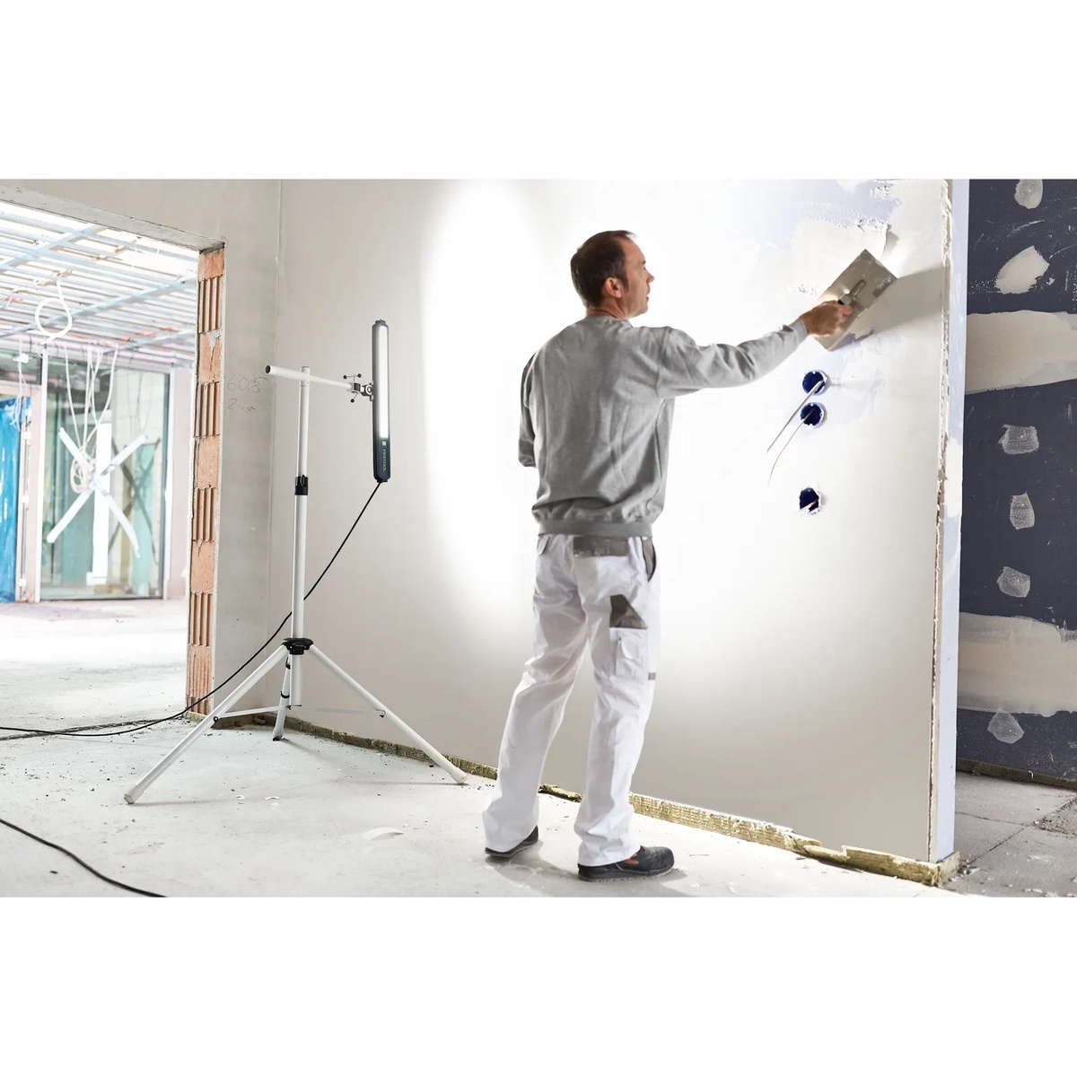 Festool Syslite Duo 200 Tripod supporting a Festool work light during wall finishing in an interior remodel jobsite