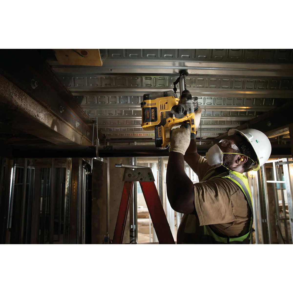 DEWALT DCH273B 20V MAX XR brushless cordless 1 in. SDS Plus L-Shape Rotary Hammer drilling overhead into steel deck and concrete on a commercial jobsite