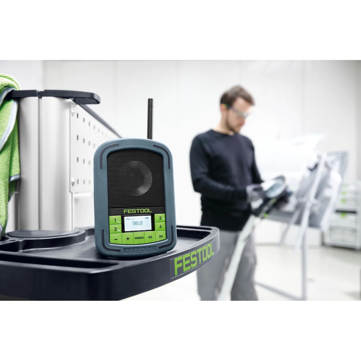 Festool 200184 BR10 SysRock Jobsite Radio sitting on a Festool cart inside a workshop near active tool setup and production work