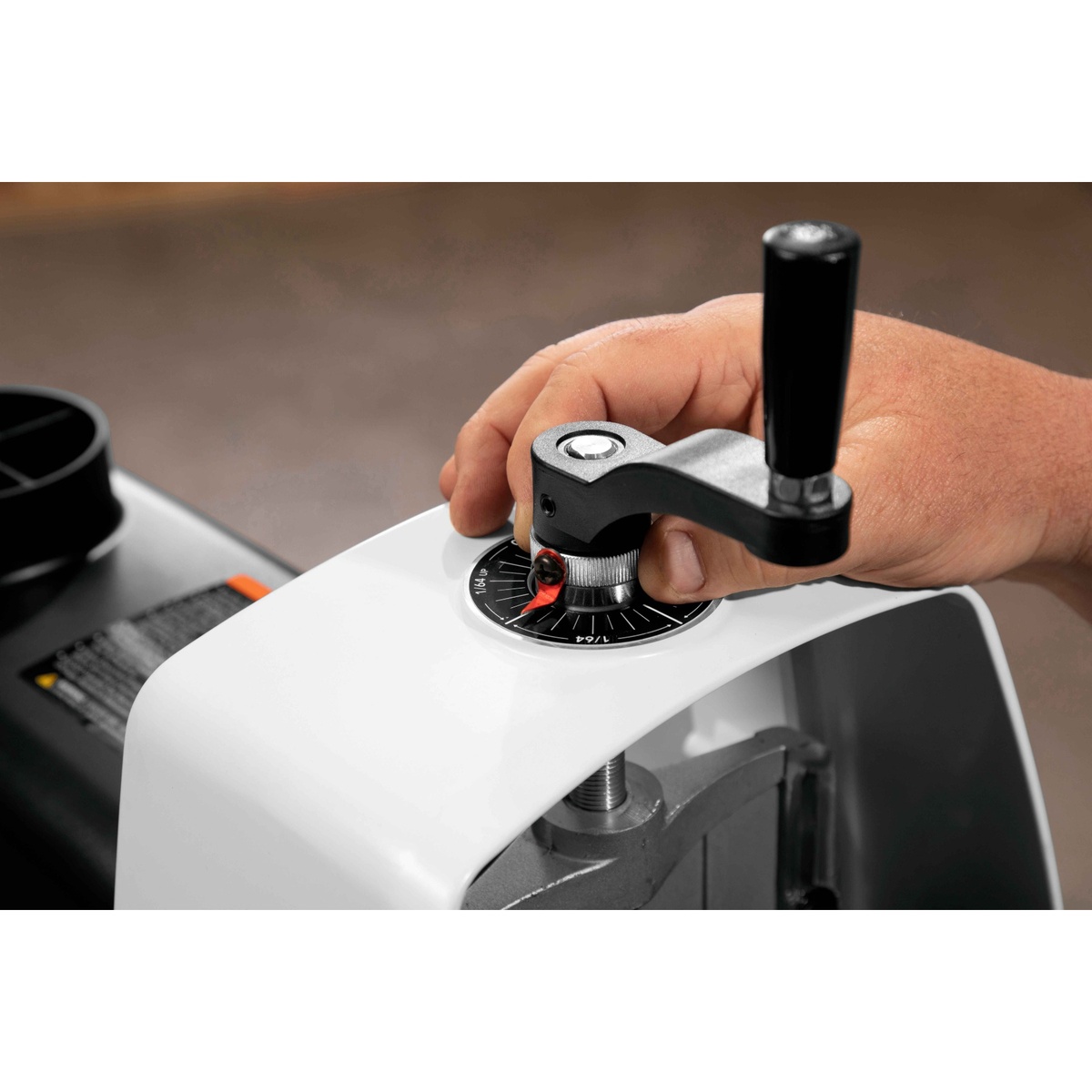 JET JWDS-1632 Drum Sander with Stand height handwheel being adjusted by hand for controlled sanding depth on wood stock in a workshop