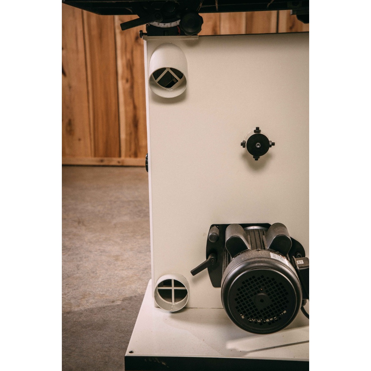 JET JWBS-15-3 15-Inch Woodworking Bandsaw rear motor area with dual 4 inch dust ports in a woodworking shop, showing dust collection connection points
