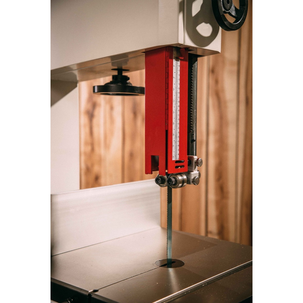 JET JWBS-15-3 15-Inch Woodworking Bandsaw guide assembly and blade over the cast iron table in a woodworking shop, showing close blade support for controlled wood cutting