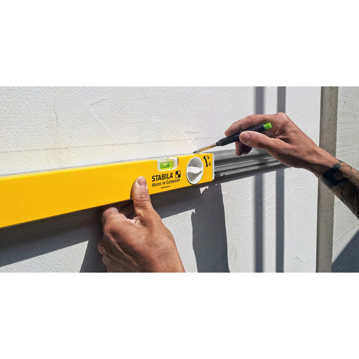 Stabila 29459 80T Adjustable Length Level, 36 to 59 inch, extended against a wall while marking a layout line during interior installation work