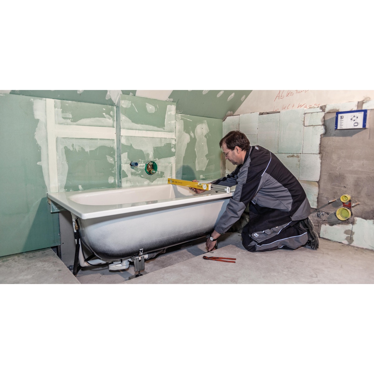 Stabila 29459 80T Adjustable Length Level, 36 to 59 inch, being used to level a bathtub during bathroom remodeling installation