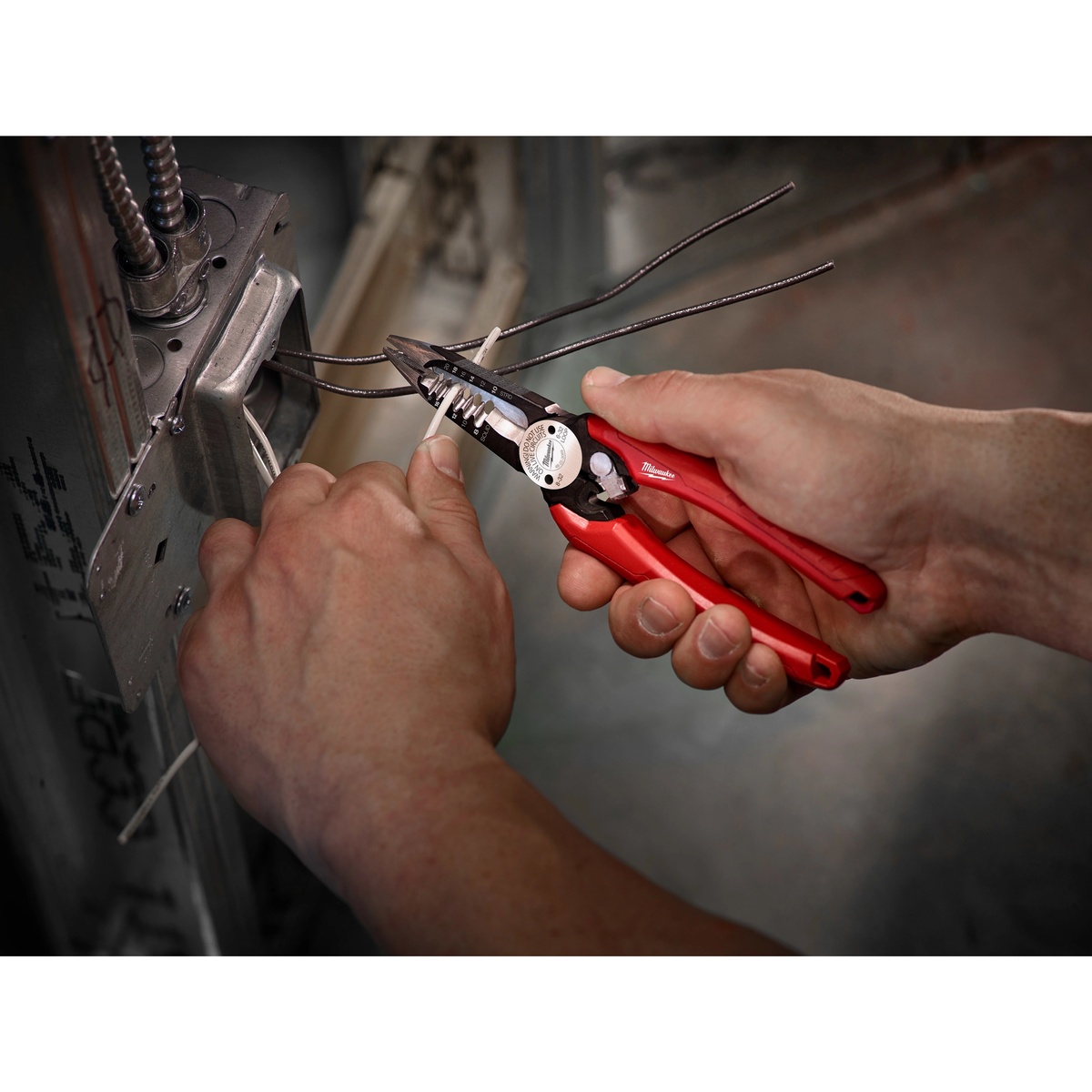 Milwaukee 48-22-3079 Combination Wire Plier stripping electrical wire inside a metal stud wall during rough electrical installation