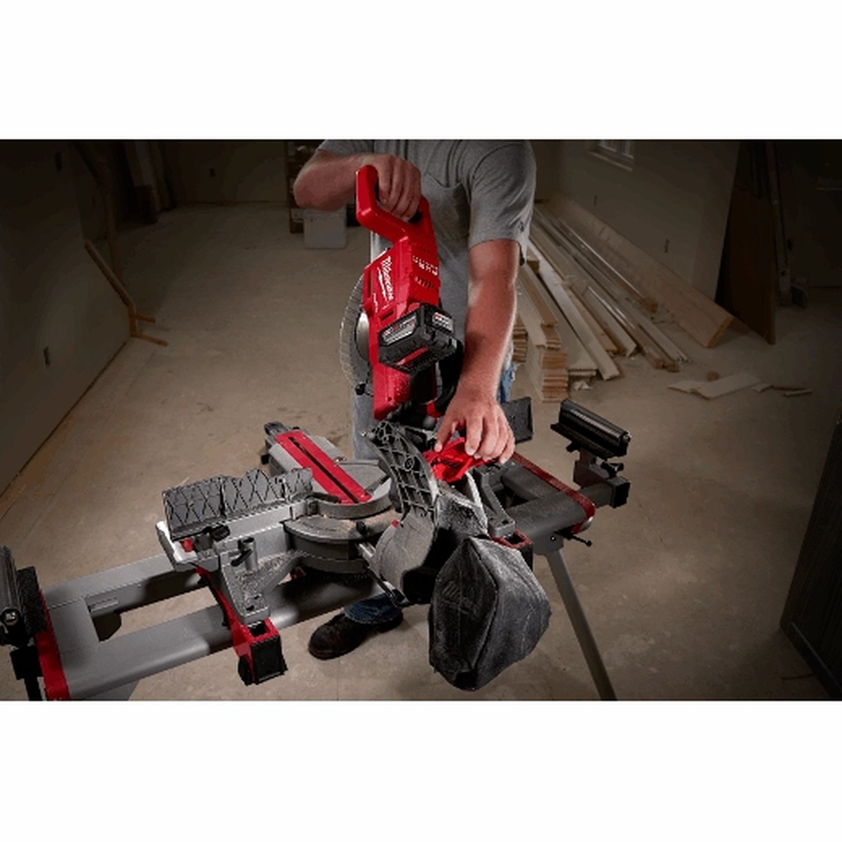 Milwaukee 10 inch cordless miter saw showing front controls and saw head positioning during setup in an unfinished room