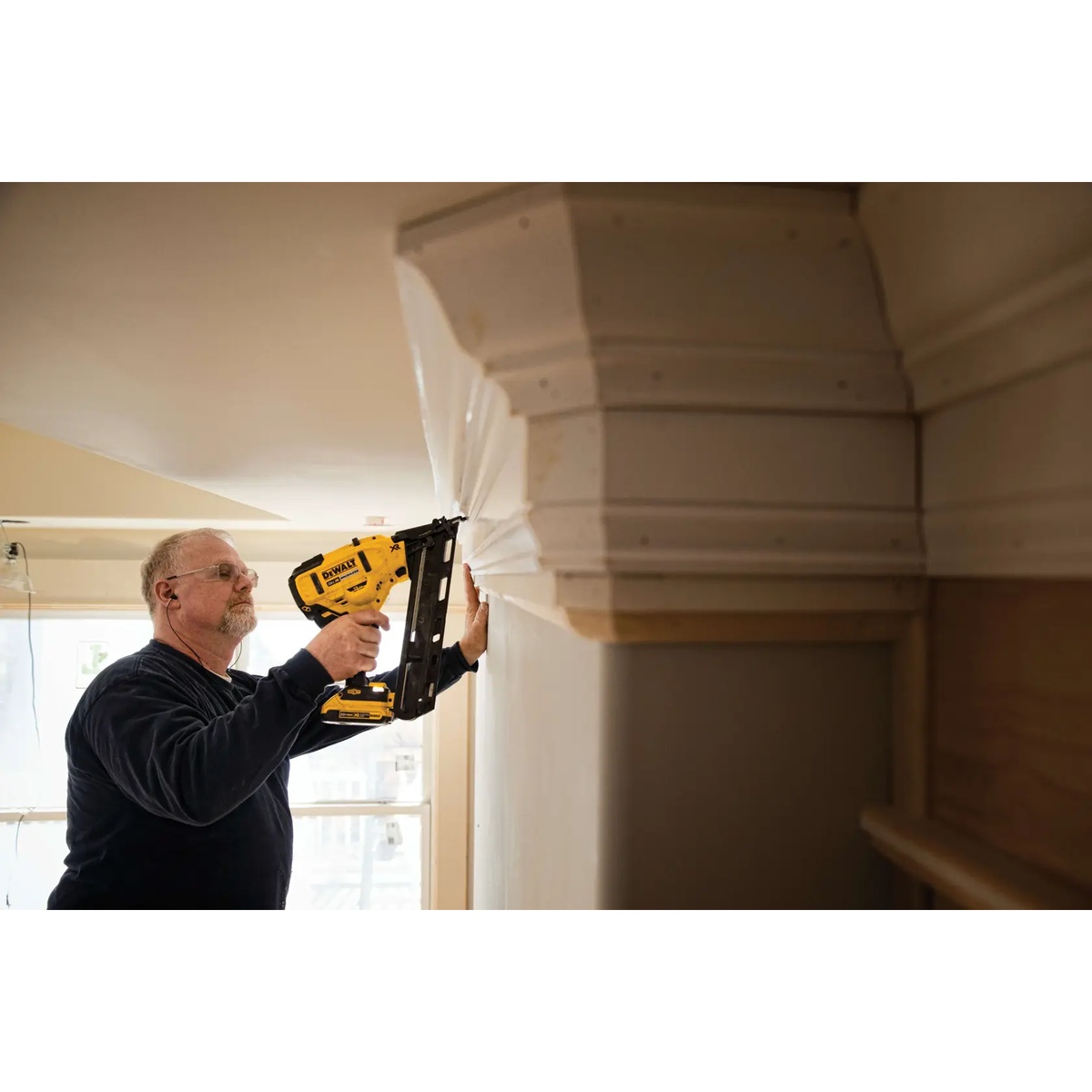 DEWALT DCN650B 20V MAX XR Cordless 15 Gauge Angled Finish Nailer installing crown molding overhead in an interior room