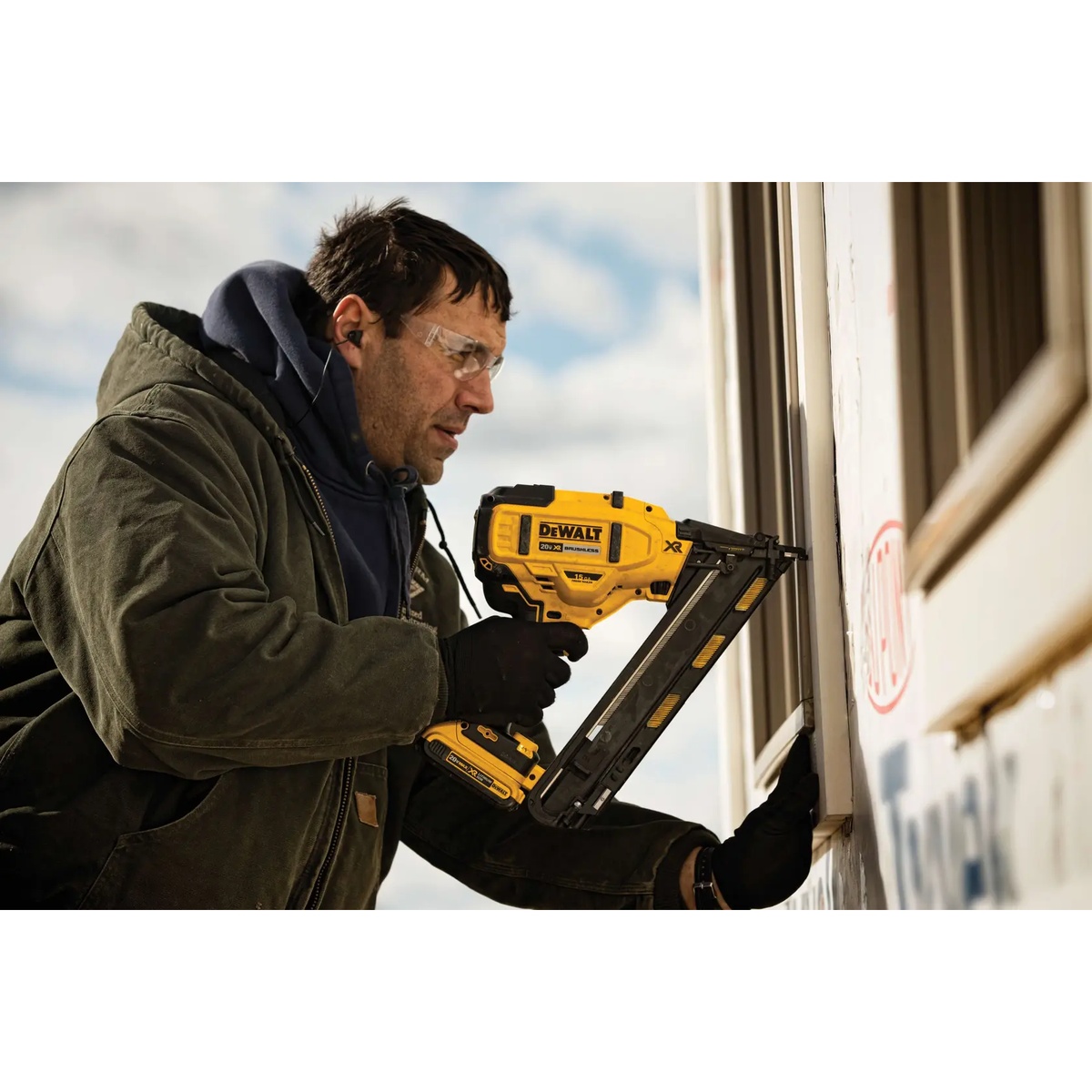 DEWALT DCN650B 20V MAX XR Cordless 15 Gauge Angled Finish Nailer fastening exterior window trim on a jobsite