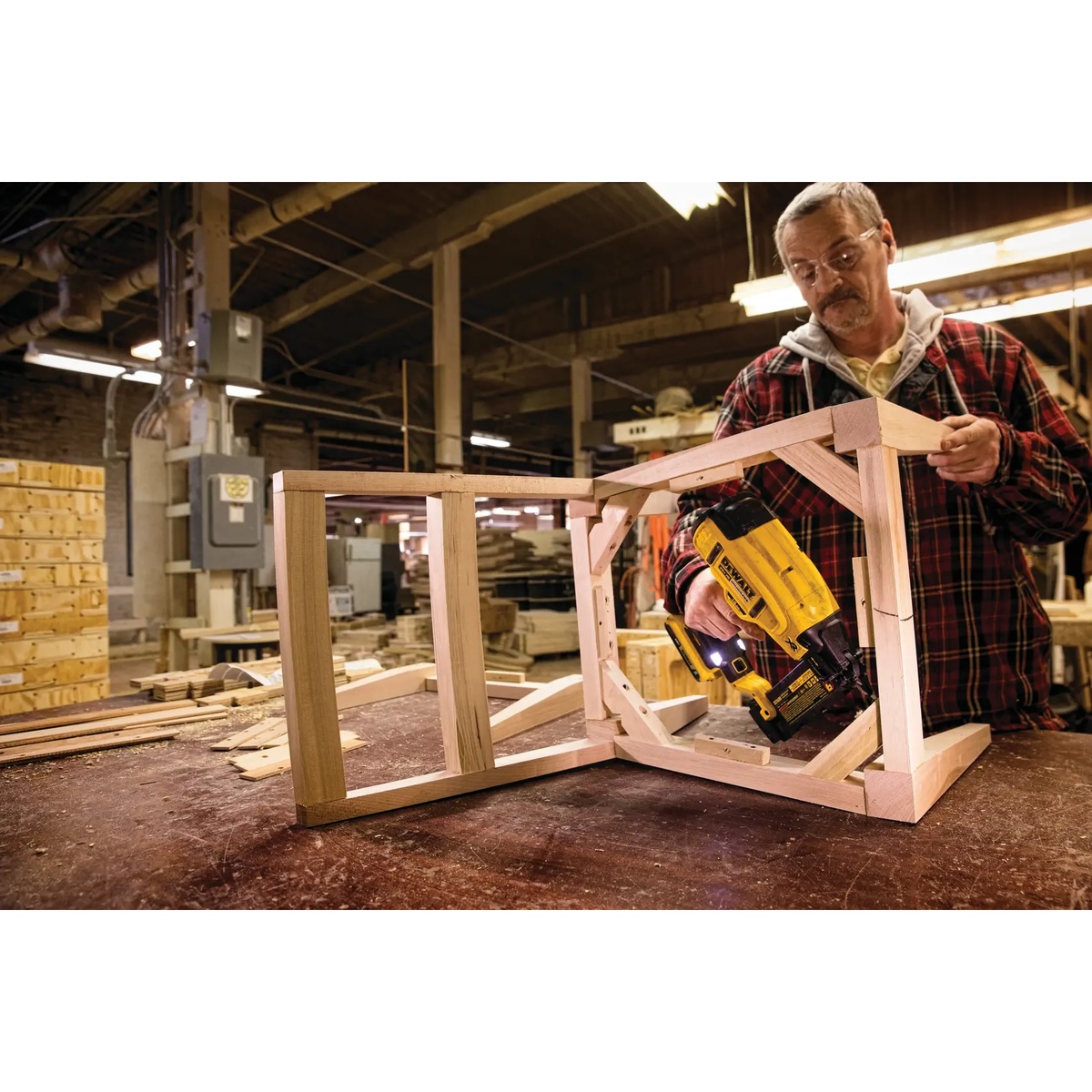 DEWALT DCN680B 20V MAX XR Cordless 18 Gauge Brad Nailer assembling a wood furniture frame on a workbench in a woodworking shop