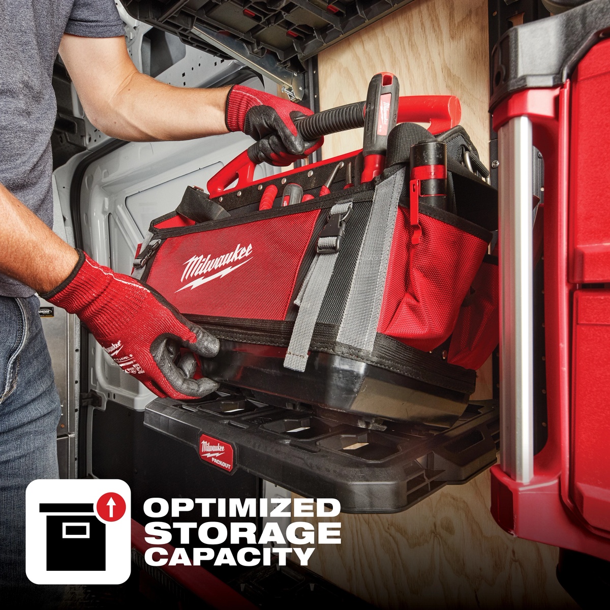 Milwaukee 48-22-8320 PACKOUT tote being loaded onto a PACKOUT base in a service van with hand tools organized for jobsite transport