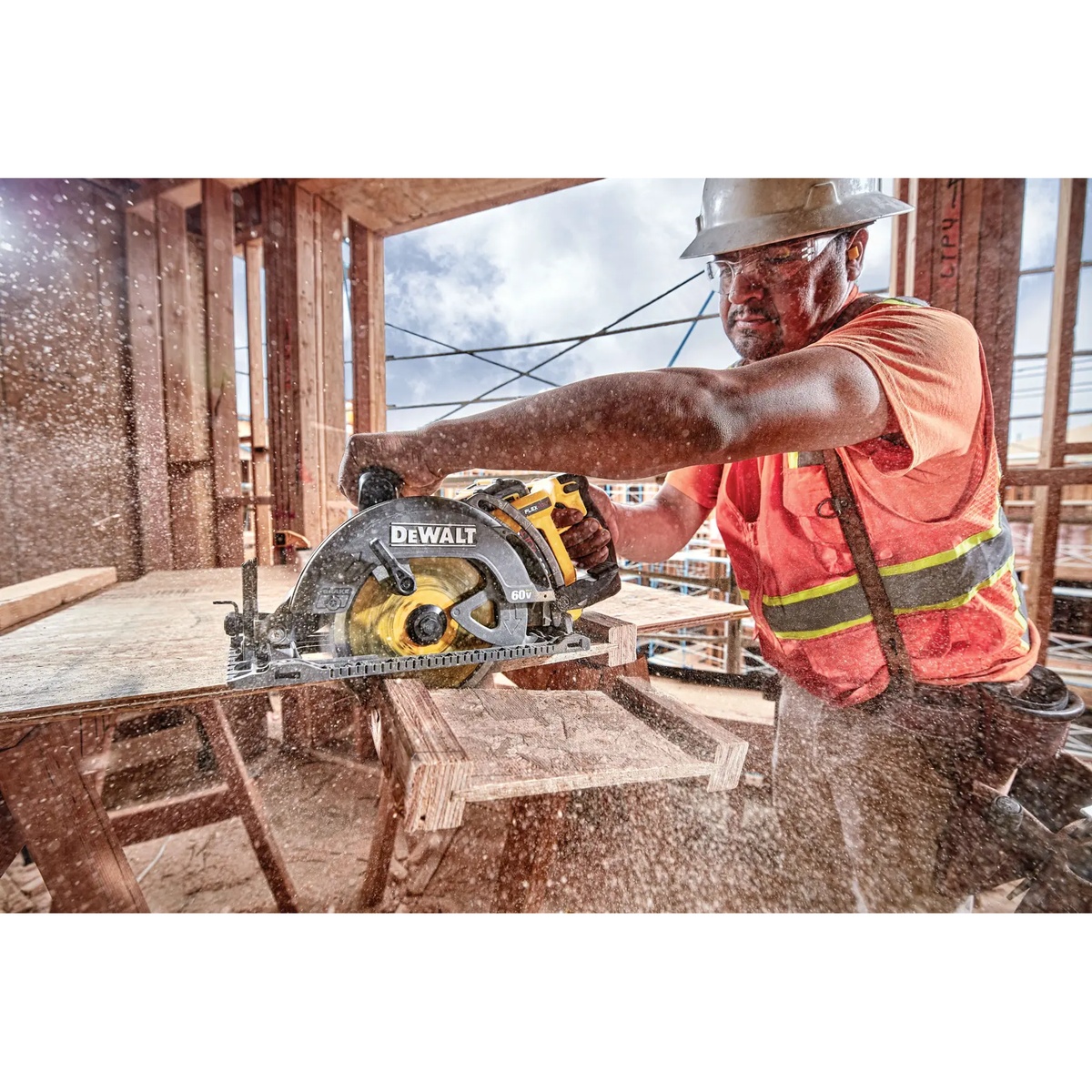 DEWALT DCS577B FLEXVOLT 60V MAX 7-1/4 in. Cordless Worm Drive Style Saw cutting wood on a framed construction jobsite with visible sawdust during framing work