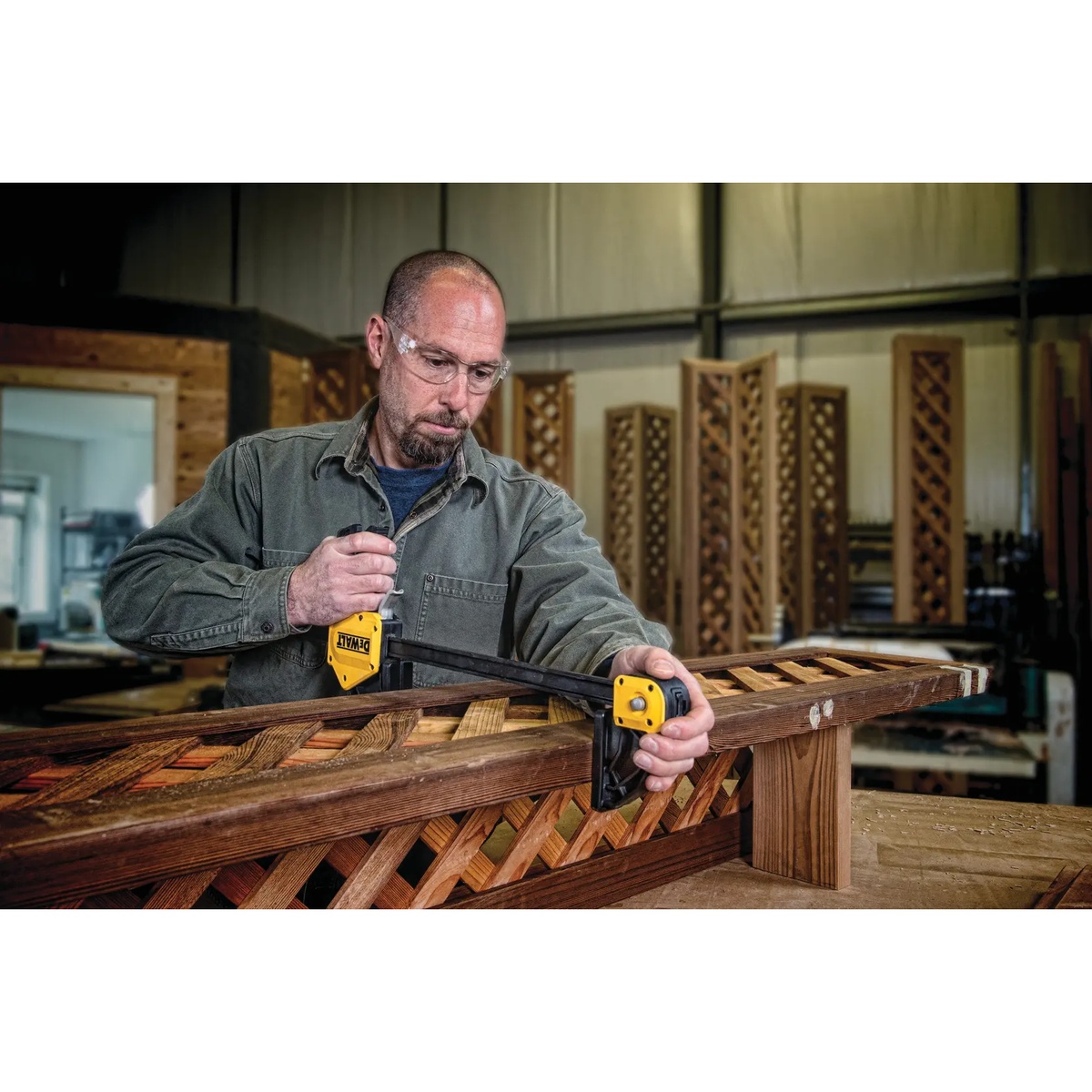DEWALT DWHT83186 24 in. Extra Large Trigger Clamp holding a wooden lattice assembly during woodworking in a shop