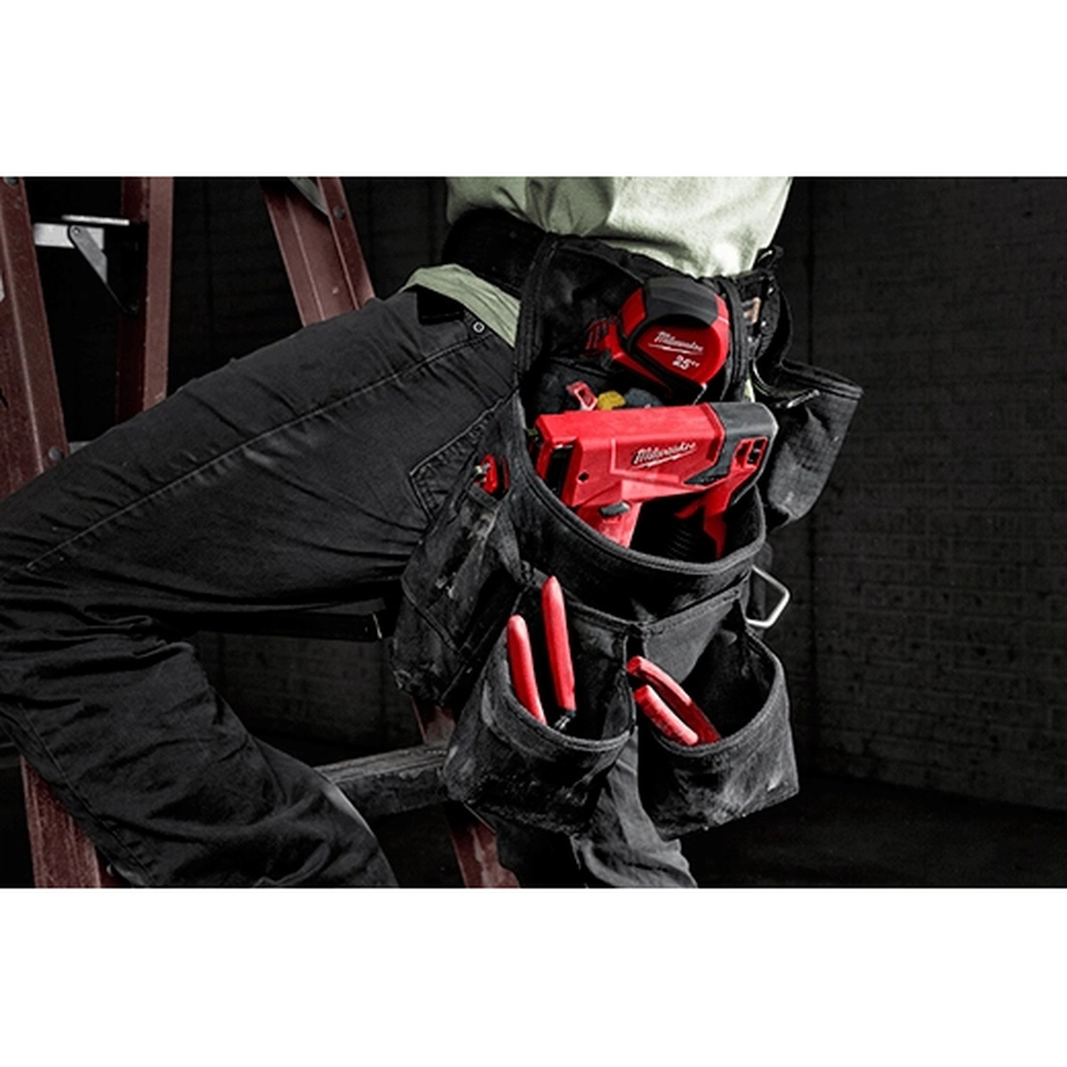 Milwaukee M12 3/8 in. Crown Stapler riding in a tool belt pouch on a jobsite for portable fastening work