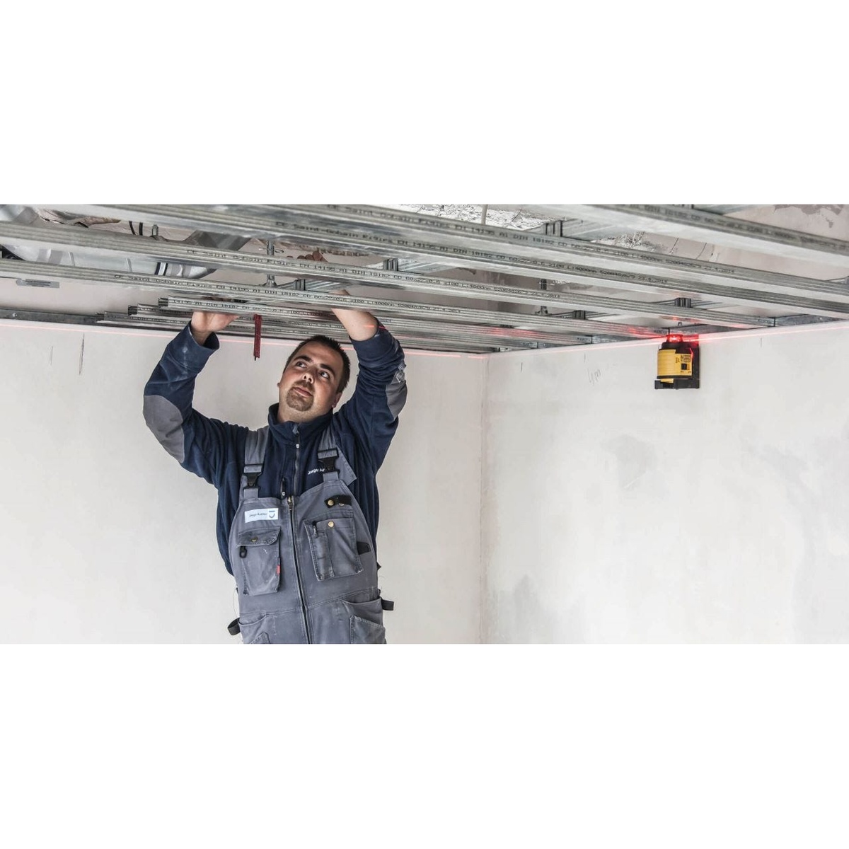 Stabila 03360 LAX 400 multi-line self-leveling laser level mounted on steel with magnetic V-groove for ceiling grid and metal stud layout