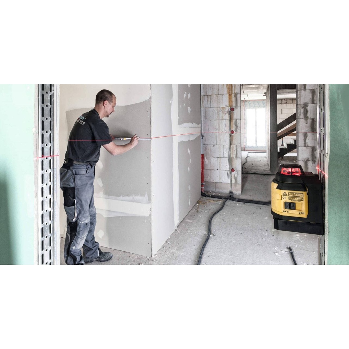 Stabila 03360 LAX 400 multi-line self-leveling laser level projecting a 360 degree red level line for interior wall layout in a renovation space