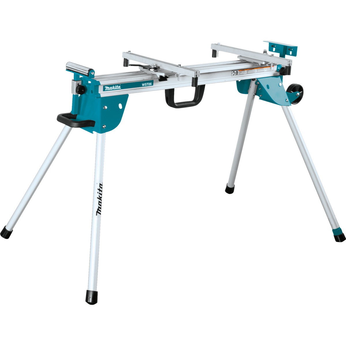 Makita WST06 Compact Folding Miter Saw Stand set up for cutting support on a jobsite-style work area, showing the aluminum frame, extension rails, carry handle, and wheel-equipped leg design
