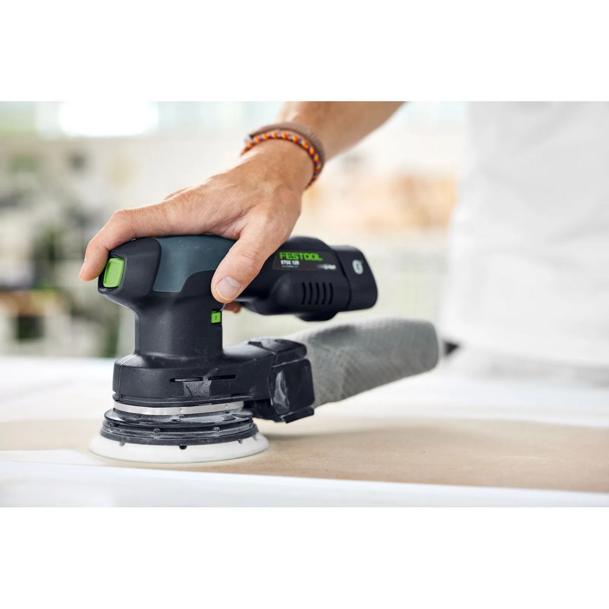 Festool random orbital sander using a 150 mm interface sanding pad on a wood surface during fine finish sanding in a workshop