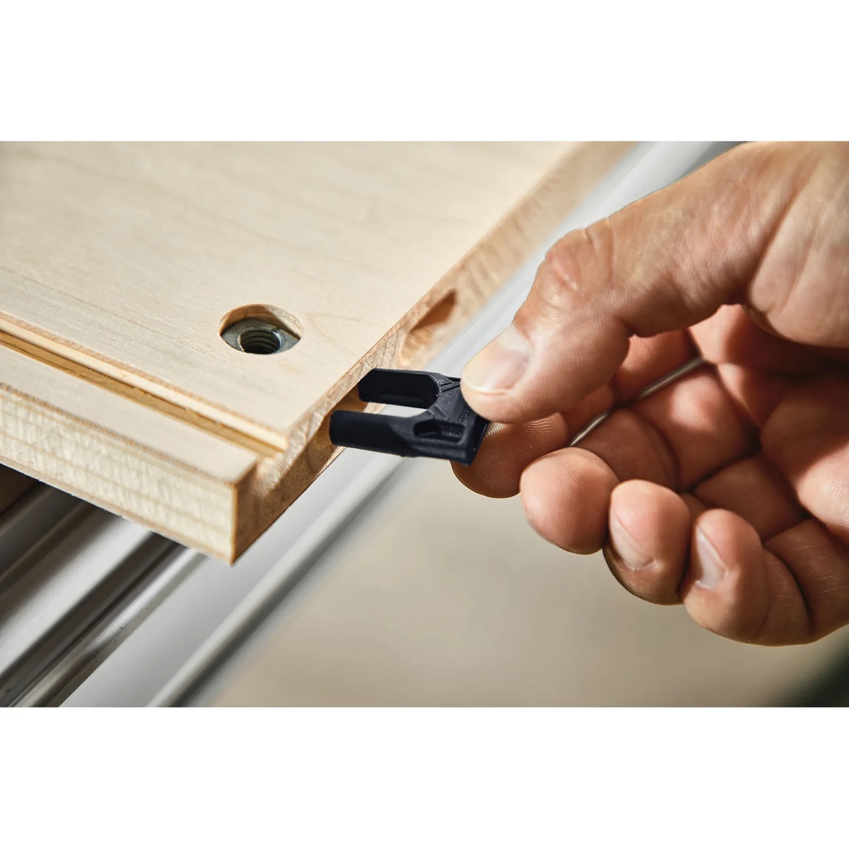 Hand inserting Festool panel connector component into a routed wood panel edge during DF 500 joinery setup