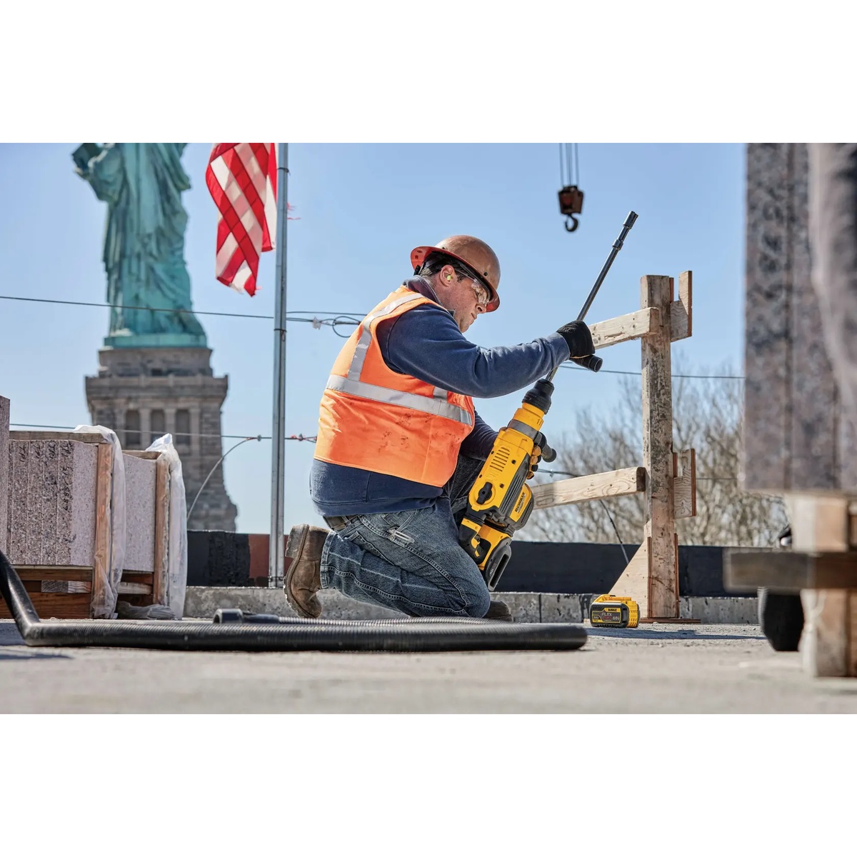DEWALT DCB612 20V/60V MAX FLEXVOLT 12Ah Battery powering a rotary hammer on a rooftop concrete jobsite during drilling work