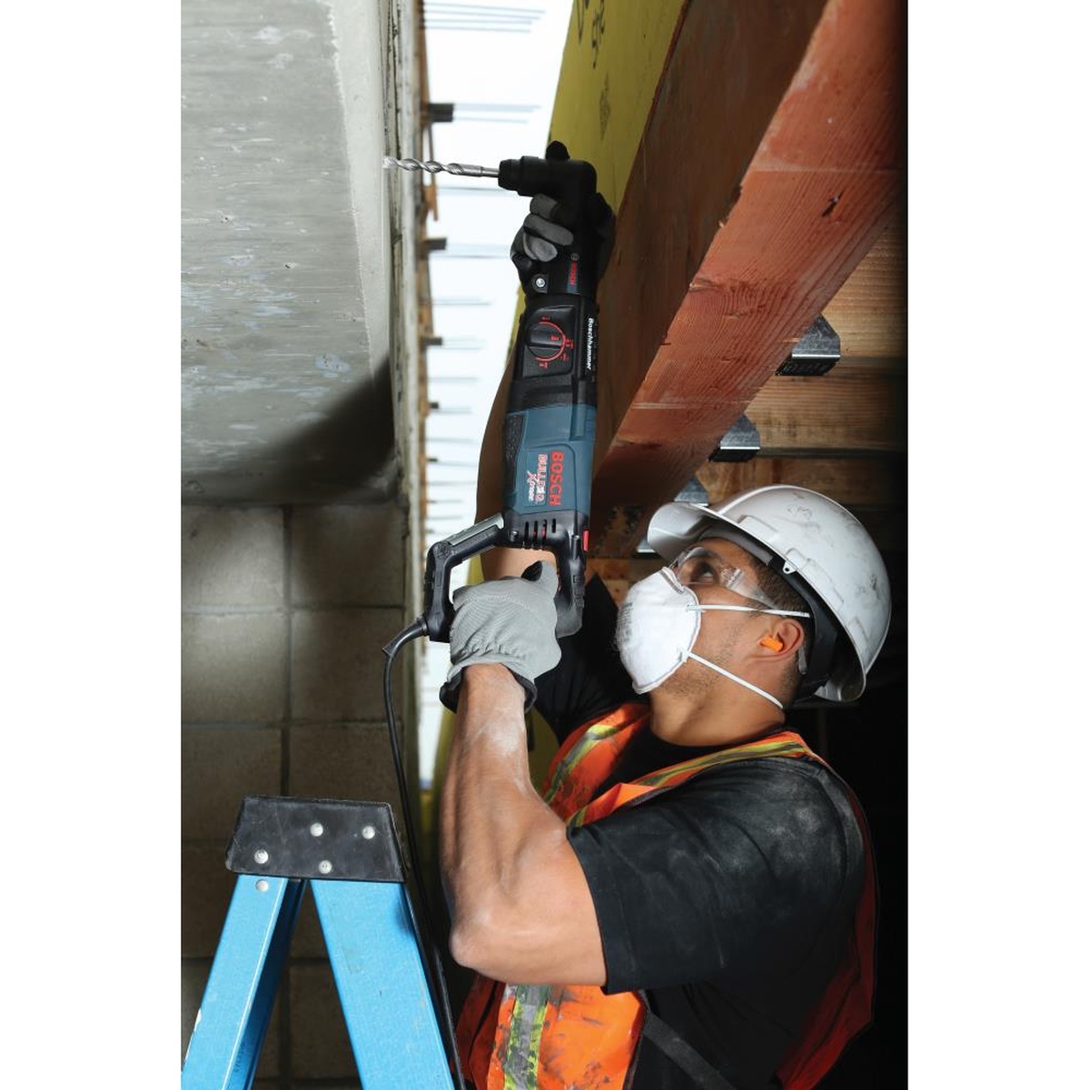 Bosch RHA-50 SDS-plus Right Angle Attachment installed on a Bosch rotary hammer drilling into concrete in a tight overhead framing area on a jobsite