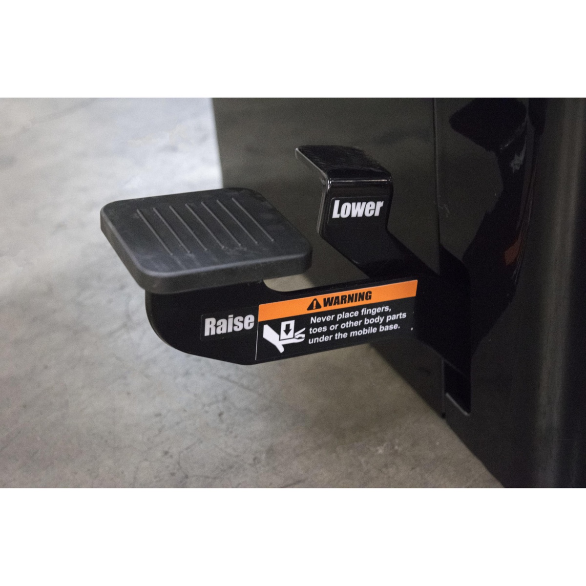 SawStop MB-PCS-000 Professional Integrated Mobile Base foot pedal close-up on a cabinet saw showing the raise and lower controls in a woodworking shop