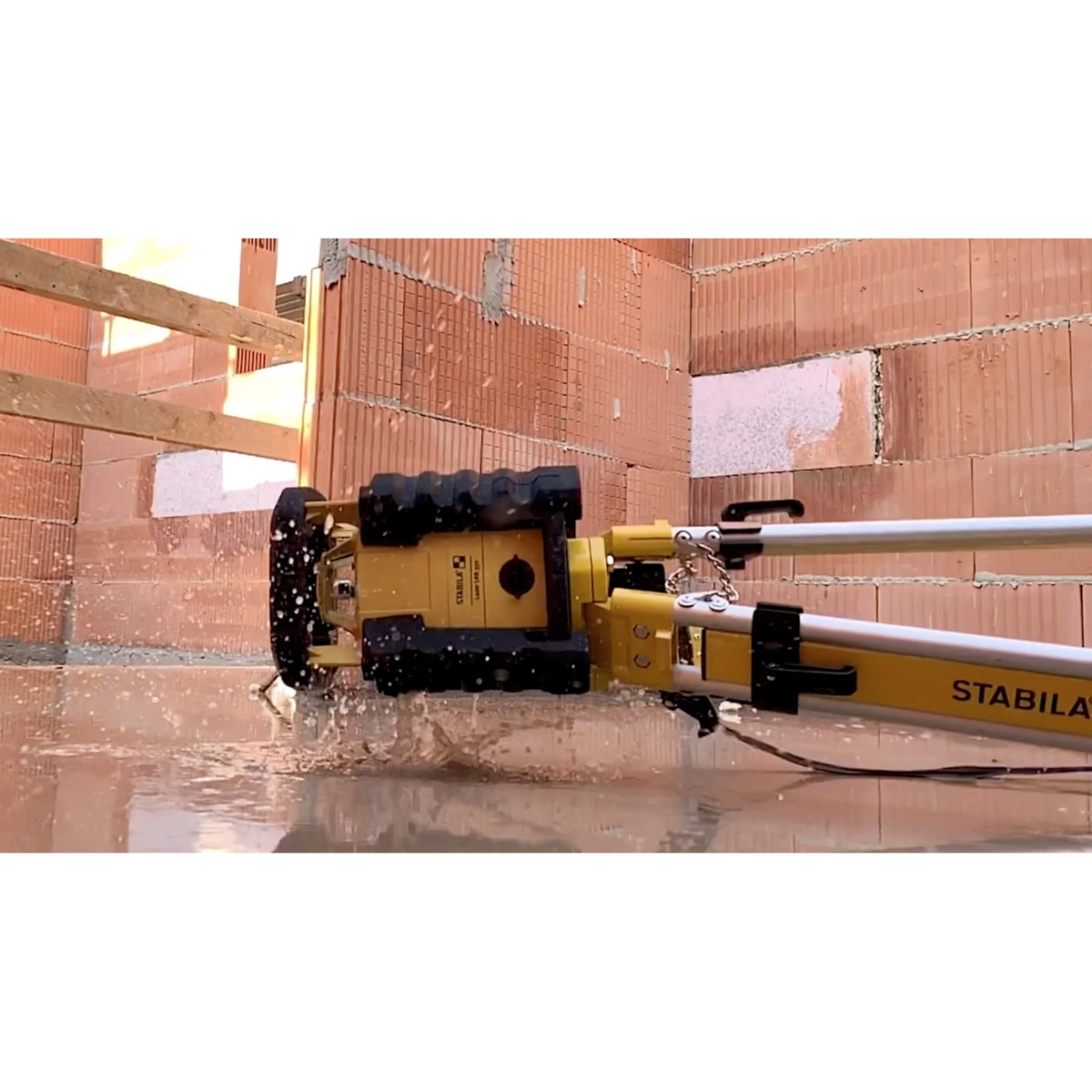 Stabila 05700TR LAR 350 Rotary Laser Kit exposed to water on a construction site to show dustproof and waterproof jobsite durability
