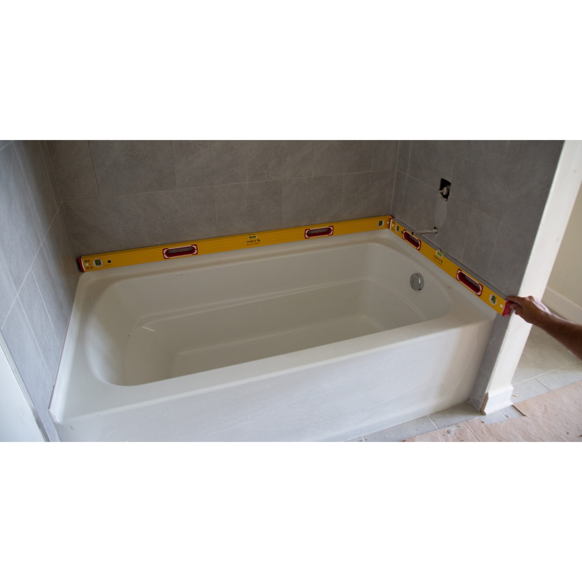 Stabila 37832 Type 196 spirit levels spanning a bathtub surround to check level lines during remodeling