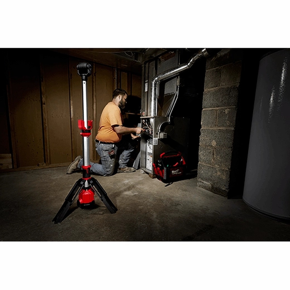Milwaukee M12 ROCKET Dual Power Tower Light illuminating a basement mechanical room for HVAC or maintenance work, reducing shadows around equipment