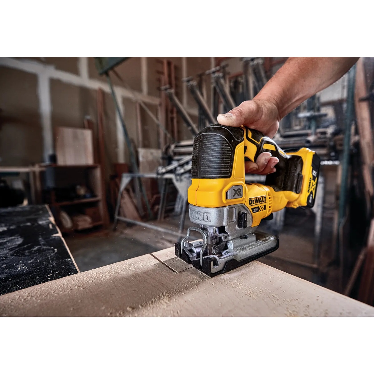 DEWALT DCS334B 20V MAX XR Cordless Jig Saw cutting a wood panel in a workshop during trim and detail cutting