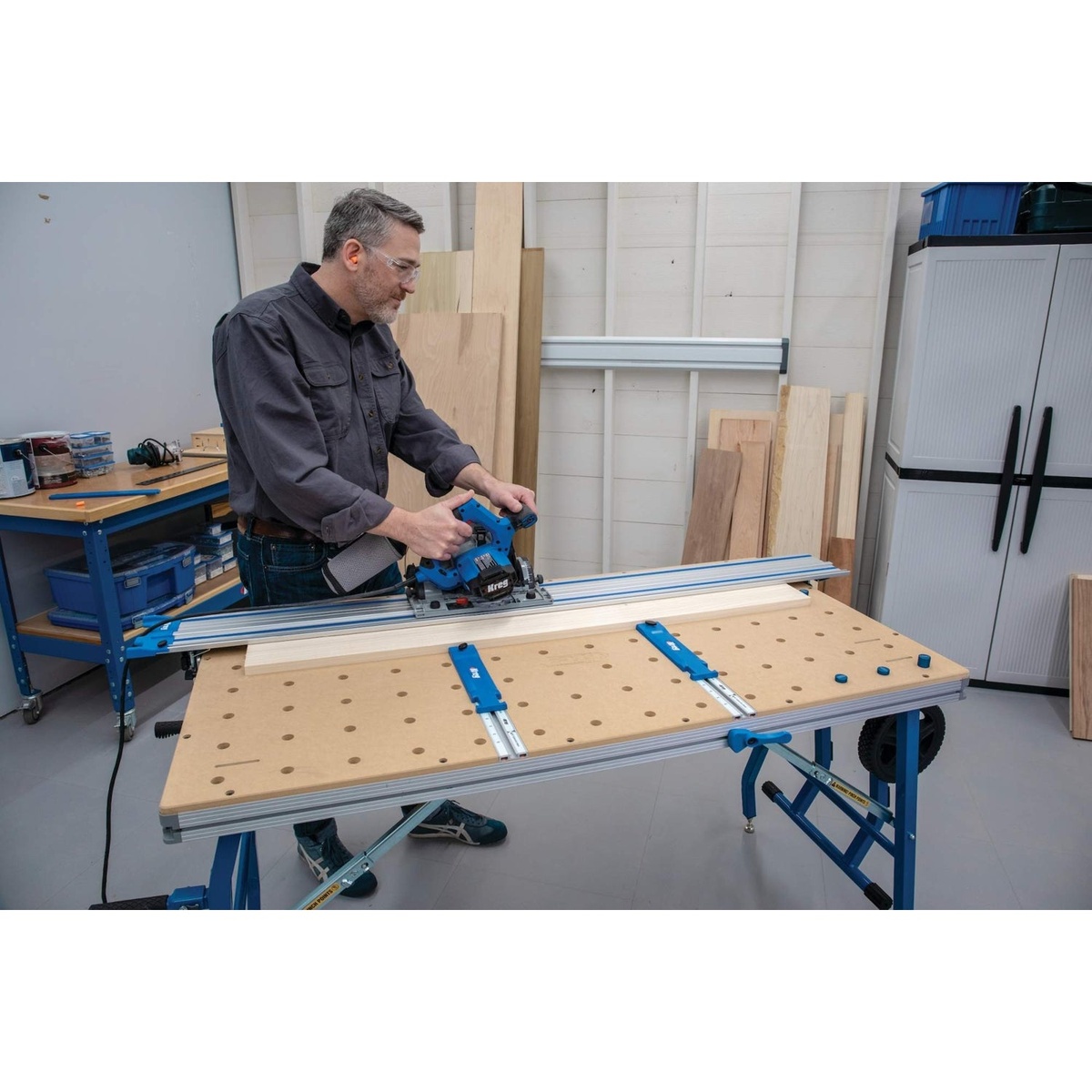 Kreg ACS1000 Adaptive Cutting System Project Table Kit set up with a mounted guide rail while cutting a board in a workshop