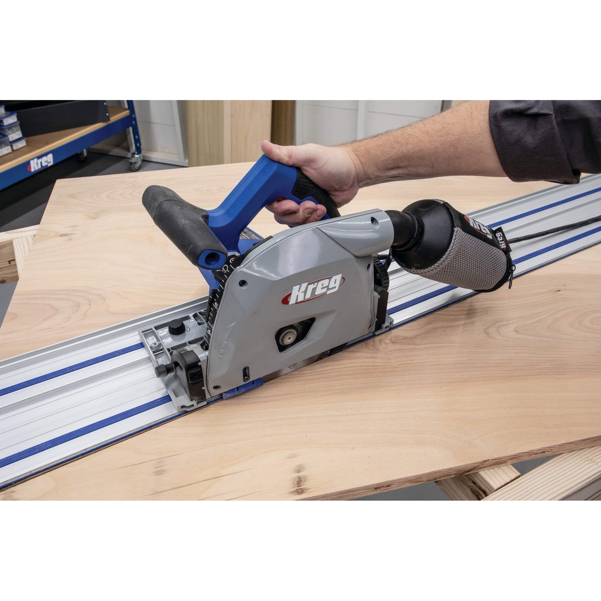 Close-up of Kreg Tool ACS2000-KIT plunge saw with dust collection attached while cutting plywood on a guide track