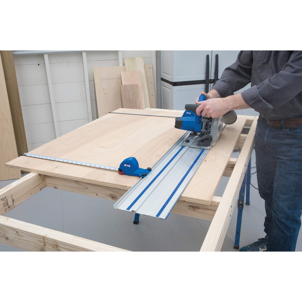 Kreg Tool ACS2000-KIT track saw making a straight cut across a large plywood sheet in a woodworking shop