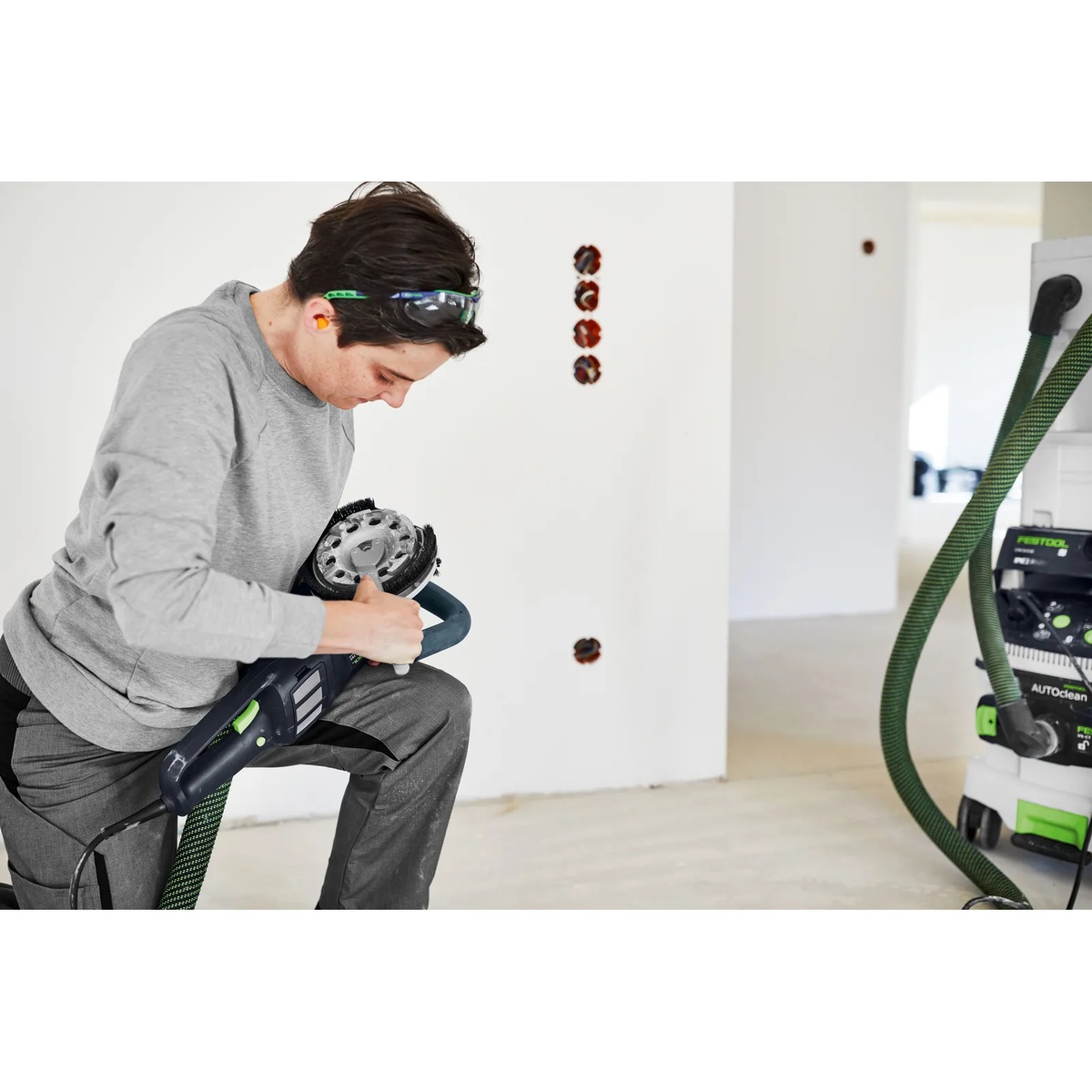 Festool 768017 DIA HARD-D130 PREMIUM Diamond Disc mounted on a renovation grinder during indoor concrete surface preparation with dust extraction connected