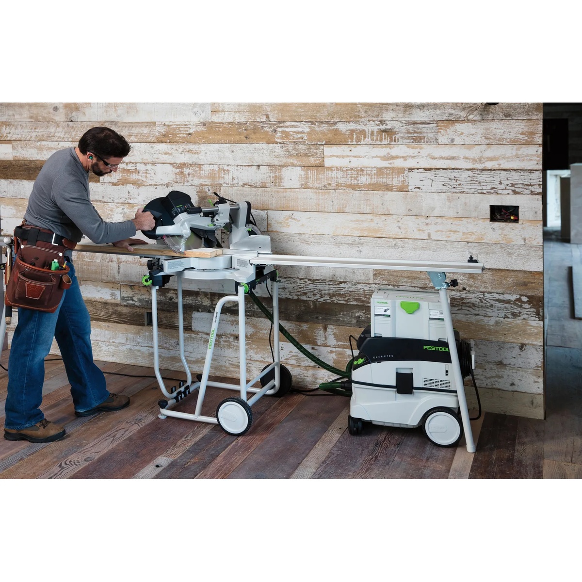 Festool Sliding Compound Miter Saw KAPEX KS 120 REB connected to dust extraction while crosscutting boards in a jobsite room