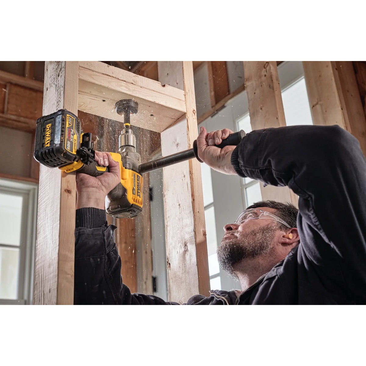 DEWALT FLEXVOLT 60V MAX Cordless Mixer/Drill with E-Clutch System drilling overhead through wood framing on an indoor jobsite