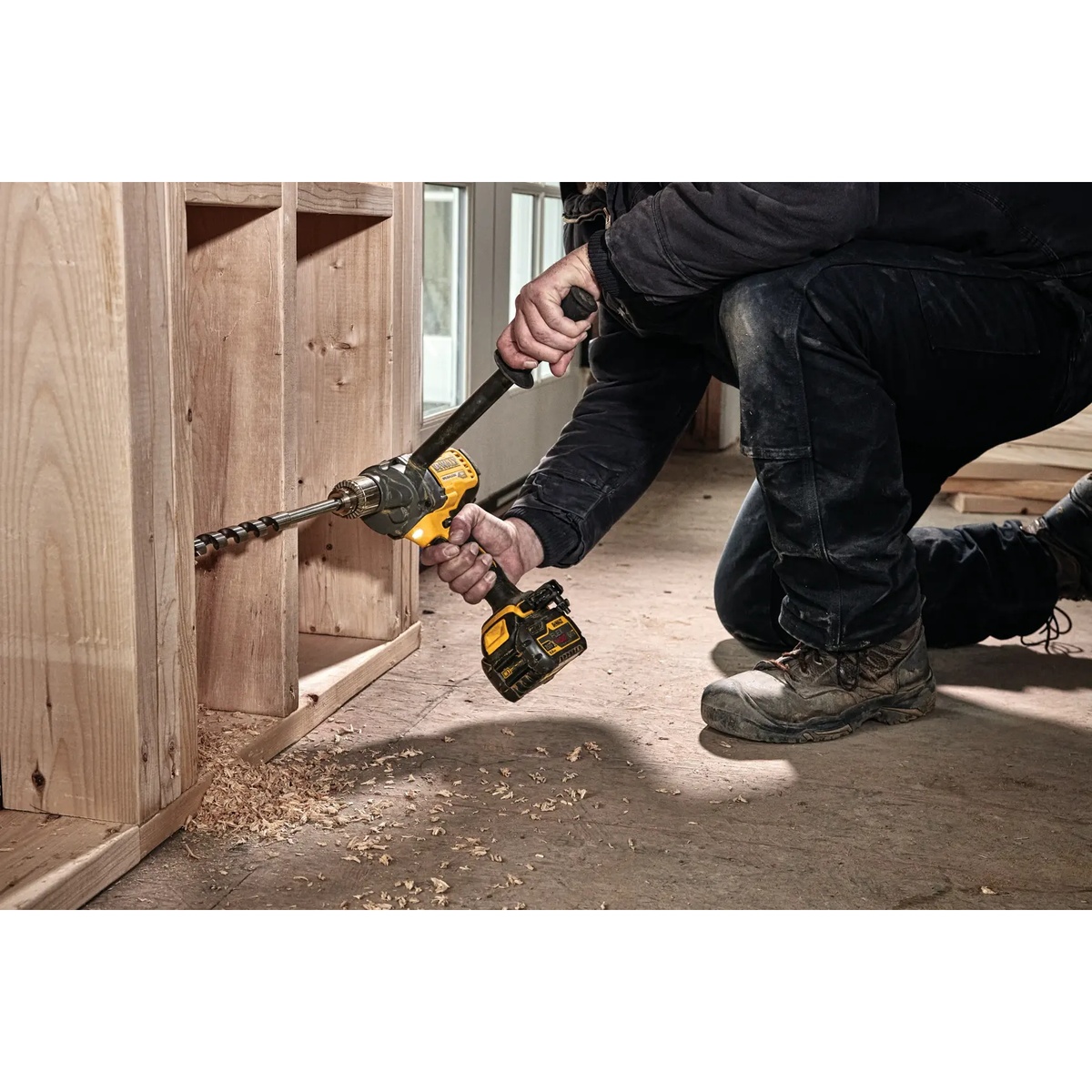 DEWALT FLEXVOLT 60V MAX Cordless Mixer/Drill with E-Clutch System boring a large auger bit through wall framing during construction