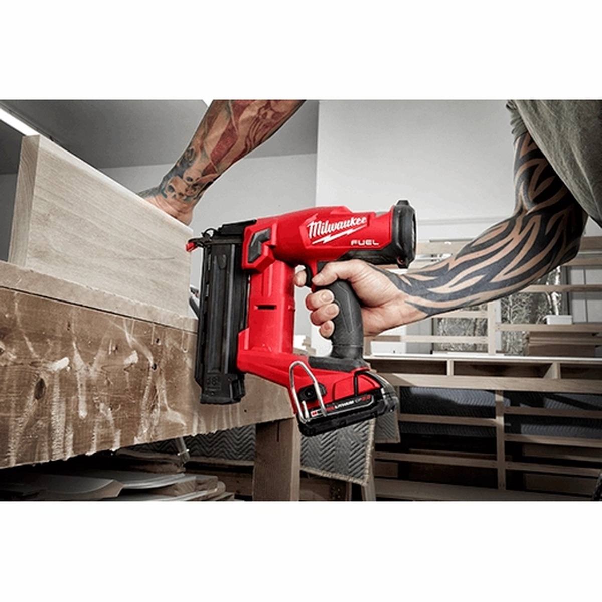 Milwaukee M18 FUEL 18 Gauge Brad Nailer fastening trim on a wood furniture or millwork assembly in an indoor shop setting