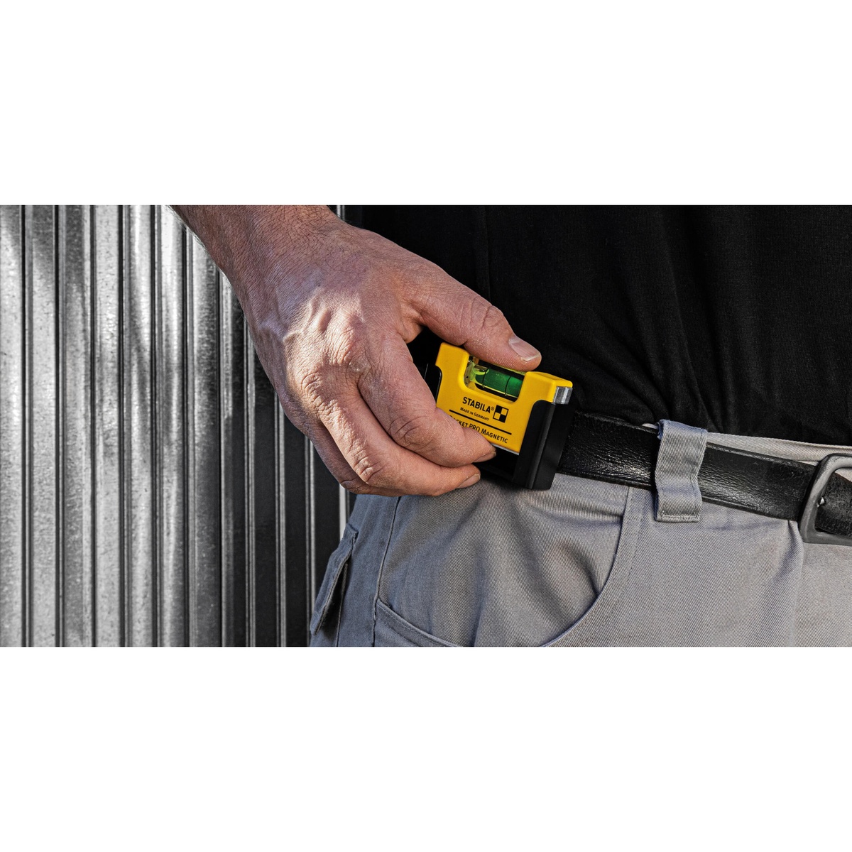 Stabila 11901 Pocket PRO Magnetic Spirit Level being pulled from a belt for quick leveling checks during metal stud and steel work