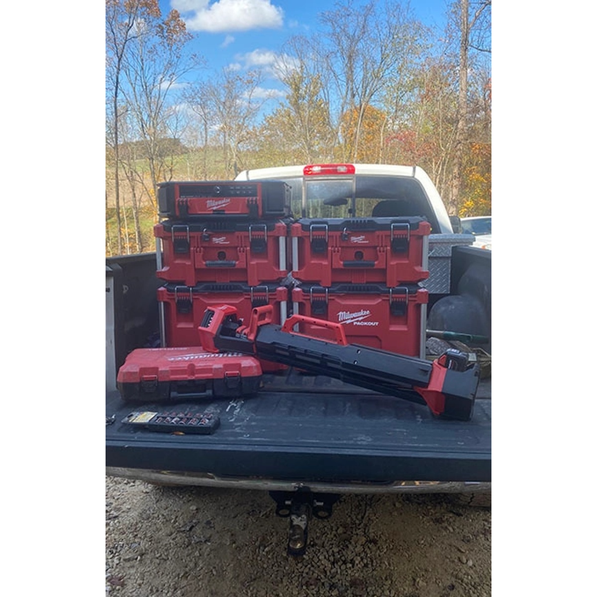 Milwaukee M18 Jobsite Radio + Charger w/ PACKOUT Compatibility loaded with PACKOUT boxes in a pickup truck bed for outdoor jobsite transport