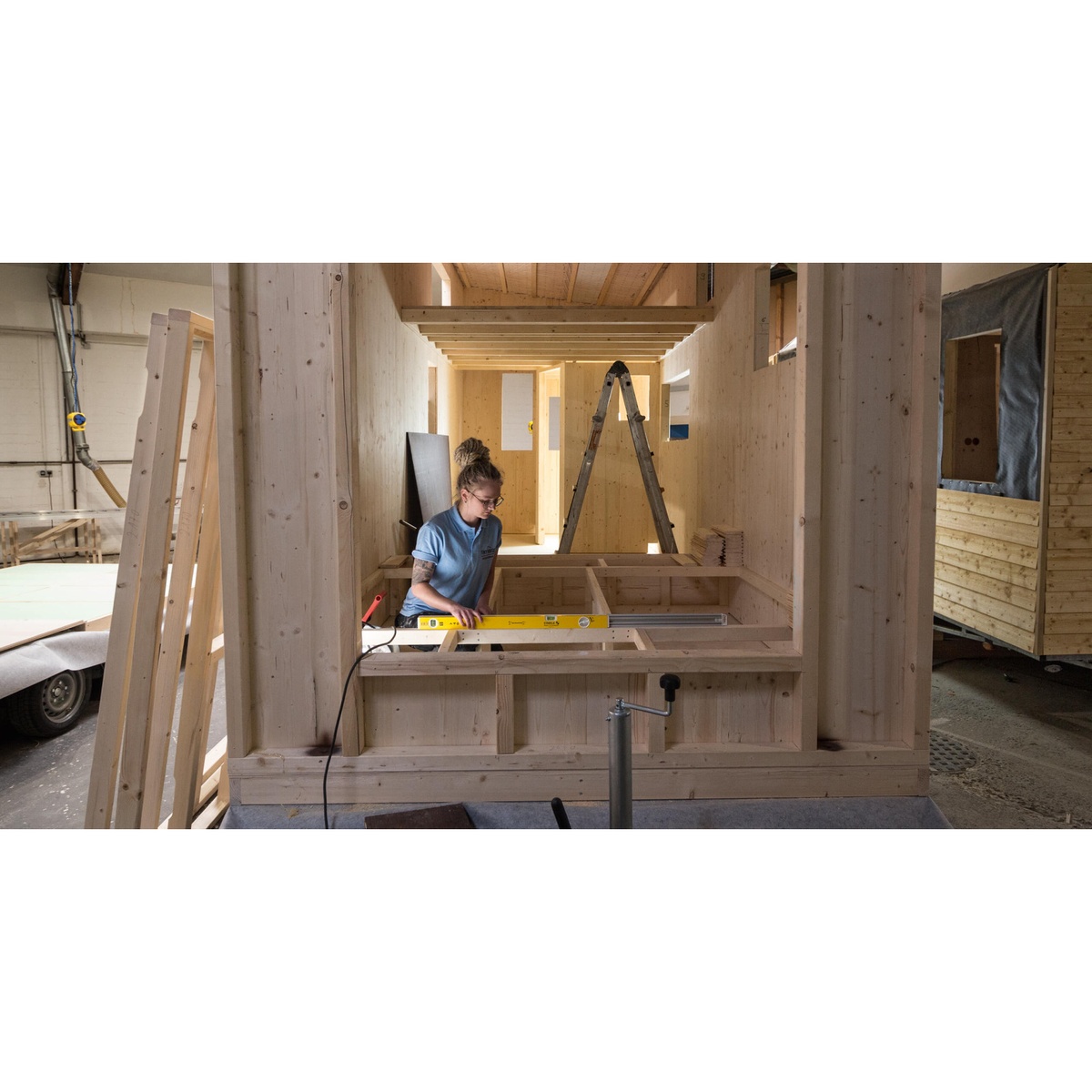 Stabila 37540 Type-196 78-inch Level and Type-80 T Extendable Level Jamber Set extendable level spanning framing members inside a wood structure during layout work