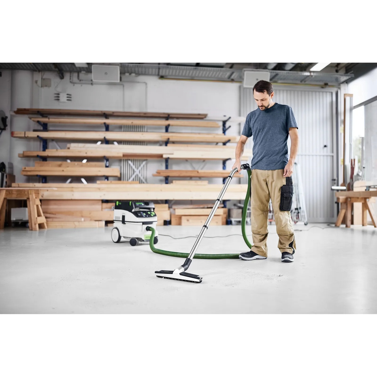 Festool Suction Hose D36x5m-AS/CTR connected to a CT dust extractor during floor cleaning in a woodworking shop