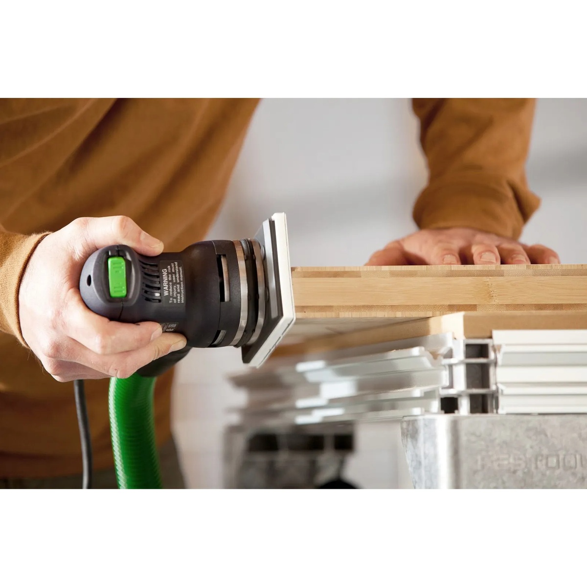 Festool 576054 RTS 400 REQ Orbital Sander sanding the edge of a wood panel on a work support during finish prep