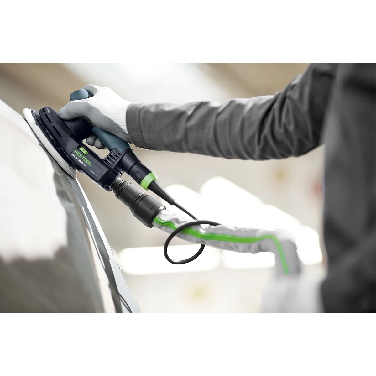 Festool ETS EC150/3 EQ-Plus Random Orbital Sander connected to dust extraction while sanding a painted panel in a shop