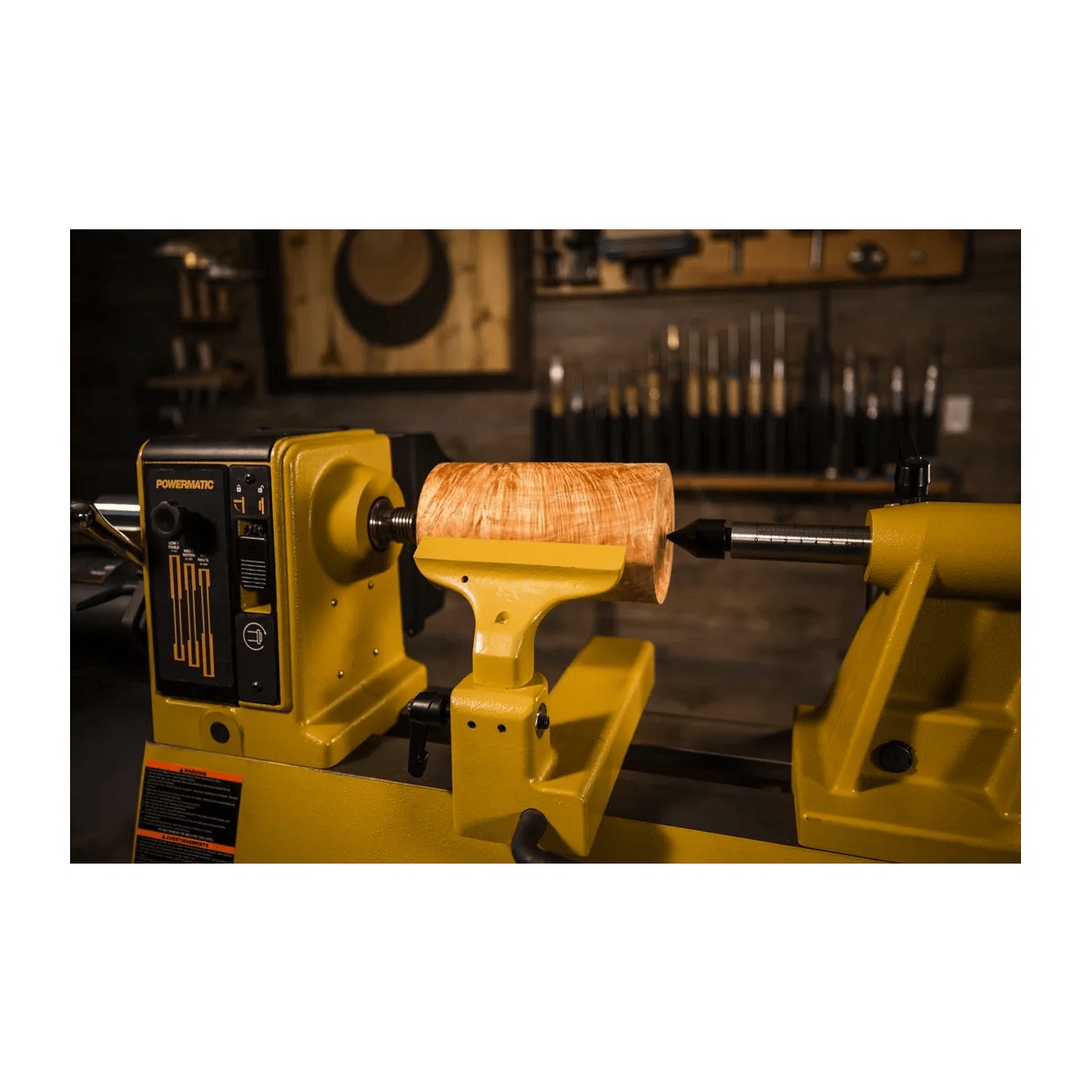 Powermatic PM2014 Lathe with Stand Kit holding a wood bowl blank between centers with tool rest set for woodturning in a shop