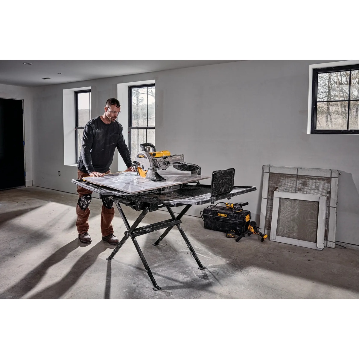 DEWALT D36000S 10-In. High Capacity Wet Tile Saw With Stand cutting a large-format tile indoors on a remodeling jobsite