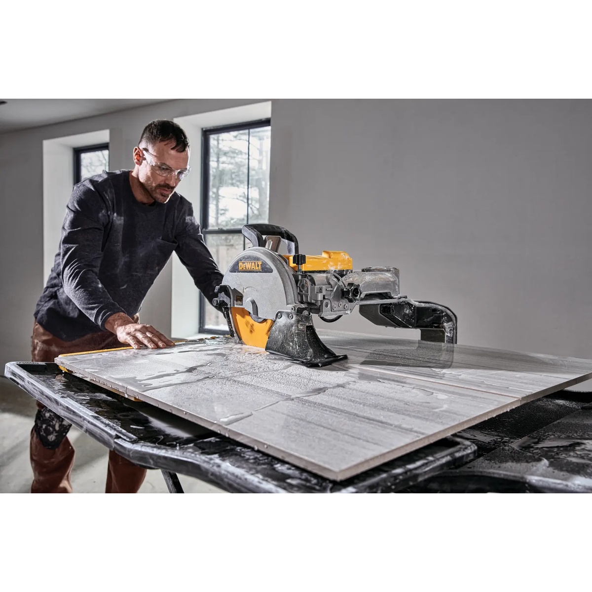 DEWALT D36000S 10-In. High Capacity Wet Tile Saw With Stand making a precise wet cut through porcelain tile during interior installation